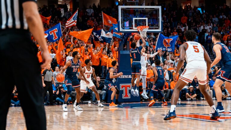 Texas Tech and Illinois college basketball players in action during a 2025 game at State Farm Center with vibrant crowd in background.