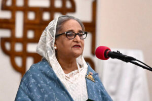 "Sheikh Hasina, Prime Minister of Bangladesh, wearing a white saree with a gentle smile and dignified expression"