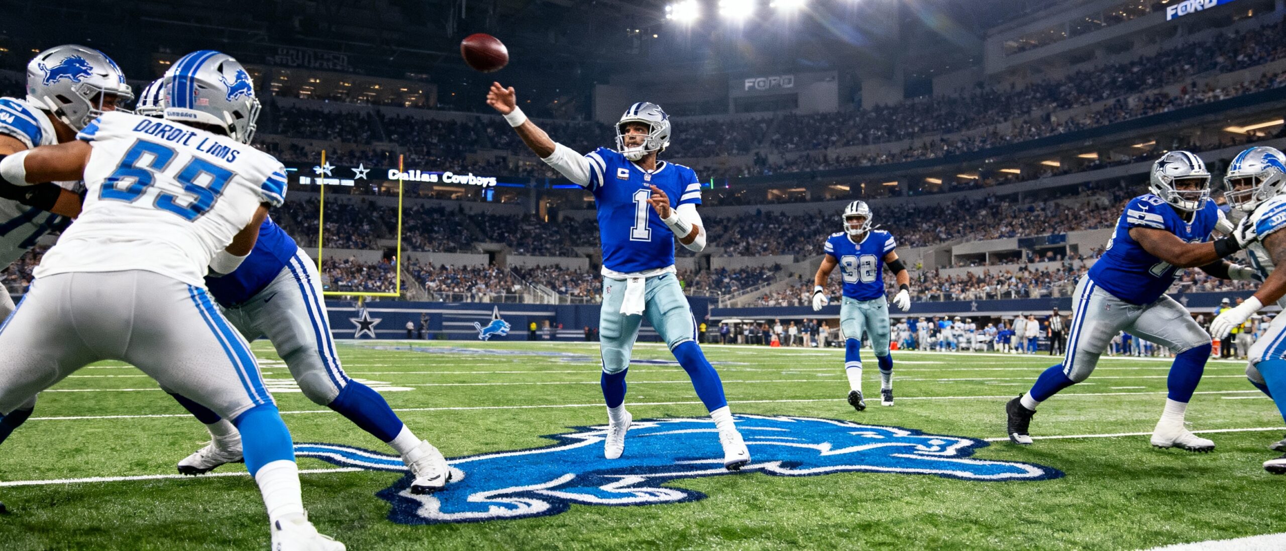 Dak Prescott in Dallas Cowboys uniform throws pass under Lions defense pressure at Ford Field during 2025 NFL Week 14 game. (see the generated image above)