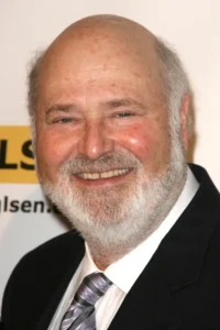 A formal portrait of Rob Reiner smiling